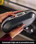 Person holding Portable Travel Lock Box With Four-Digit Combo, Small Personal Safe For Phones, Passports, Cash And Cards, Secure Your Gear On The Go, Cable Ready And Easy To Use, Gunmetal Grey 5900D showing four-digit combo lock