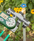 Automatic Yard Watering System With Four Station Sprinkler Setup attached to garden faucet with digital display and hose connections.