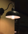 G25 LED Filament Vanity Bulb 40W Equivalent lit in black wall sconce, emitting warm glow, 500 Lumens, 2700K Warm White