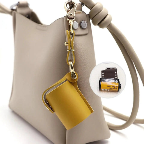 Compact Water Film Holder Case With Keychain Clip shown on a beige bag for on-the-go camera gear and outdoor shoots