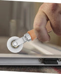 Close-up of a hand using a spline roller from the Window Screen Repair Tool Kit Spline Roller Set For Quick And Precise Screen Fixes, DIY Replacement Kit.