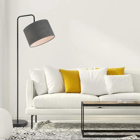 Barden 58 Inch Floor Lamp in Black Finish With Dark Gray Velvet Shade beside a white sofa in modern living room.