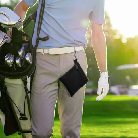 Golfer carrying Durable Golf Tee Pouch With Zipper And Clip 600D Polyester Ball And Tee Bag on belt next to golf bag on course.