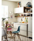 Modern kitchen with Refurbished Single Handle Faucet Kit LL on sink, surrounded by white cabinets, and colorful chairs.