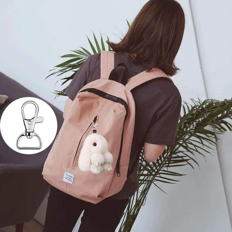 Top Shelf 60 Piece Bag Making Hardware Kit Featuring Swivel Snap Hooks D Rings Slide Buckles For Handbag Repairs Backpack Fasteners And Totally Sweet DIY Craft Builds In Polished Silver, showing a swivel snap hook on a pink backpack.