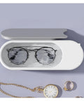 Portable Ultrasonic Cleaner For Jewelry Eyeglasses Retainers And Watches Pink Multifunctional Cleaning Gadget showing black glasses in clean water.