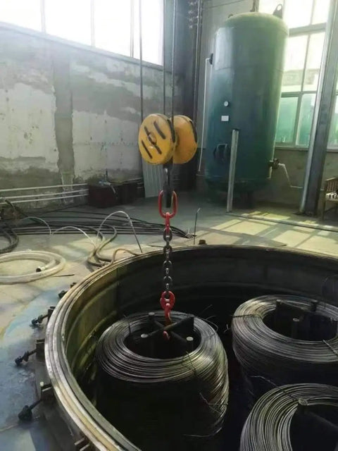 Rock Solid Single Leg Chain Sling - 2 Ton Heavy Duty Lifting Chain in use lifting wire coils in an industrial setting.