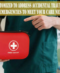 Person holding a red 196 Piece Waterproof Hard Shell Portable First Aid Kit For Home Car Camping Hiking Travel And Outdoor Adventures With Essential Medical Supplies In Red, featuring a cross symbol.