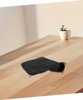 Heavy Duty Sawdust Collection Bag For Miter Saws And Bench Planers Featuring No Sweat Setup, black fabric pouch on wooden table.
