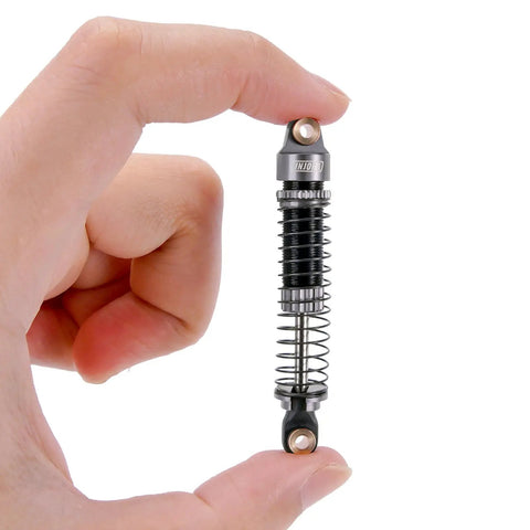Close-up of a 59mm Long Threaded RC Shocks Oil Dampers Upgrade For TRX4M TRX4MT 1/18 Crawler held between fingers.