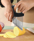 YuCool onion slicer with blue handle and 2 stainless onion holders slicing crinkle-cut potato on cutting board