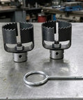 Heavy Duty Three Piece Drain Auger Set Featuring Tough As Nails Steel Cutter Heads For Knocking Out Grease And Hair Clogs In 4 Through 8 Inch Pipes on metal surface.