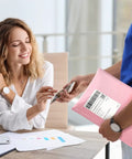 Person handing Light Pink Bubble Mailers 8.5x12 Inch 25 Pack Padded Envelopes to a seated woman.