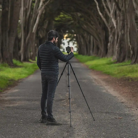 Man using Carbon Fiber Travel Tripod With Pro Level Stability, Fast Setup And Takedown, Ergonomic Ball Head outdoors.