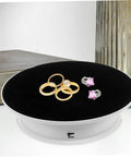 Premium Rotating Jewelry Display Stand With Smooth Electric Turntable Spin For Selling Accessories And Cosmetics featuring rings on black velvet surface.