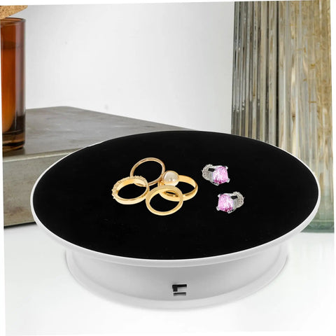 Premium Rotating Jewelry Display Stand With Smooth Electric Turntable Spin For Selling Accessories And Cosmetics featuring rings on black velvet surface.