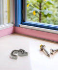 Essential Black Plastic Refrigerator Door Stopper Clip For Modern Kitchens With Universal Compatibility and Secure Closure, gray clip on wooden surface.