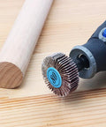 Close-up of a rotary tool with 20 Pack 80 Grit Flap Wheel Sander Set With Pro Grade One Eighth Inch Shank on a wooden surface