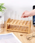 Hand placing tube in Wooden 24-Hole Bamboo Test Tube Rack Rectangle Lab Organizer For 20mm Diameter Tubes on desk.