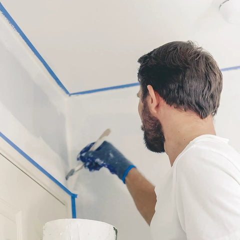 Man using Blue Painters Tape 180 Yards Removable Masking Tape For Painting And DIY Projects With Sharp Edges For Walls Wood Glass And Trim