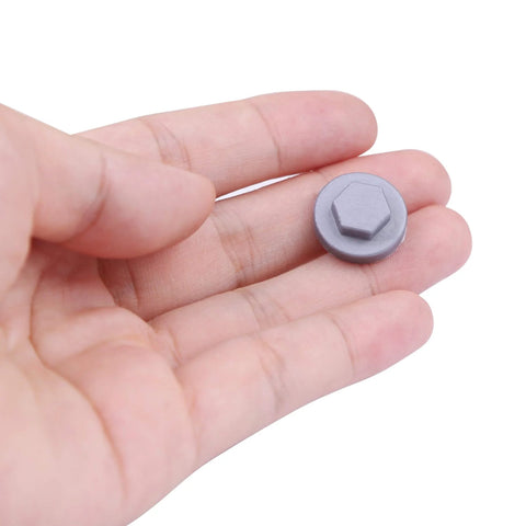 Hand holding a single silver gray plastic screw cover, part of 400 Pack Silver Gray 8mm Roofing Screw Covers, Durable Plastic Snap-On Protectors.