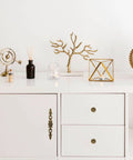 White cabinet decorated with vintage bronze patina finish hardware in retro flower pattern pulls, ideal for farmhouse and vintage interiors.