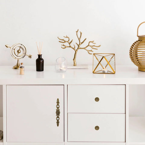 White cabinet decorated with vintage bronze patina finish hardware in retro flower pattern pulls, ideal for farmhouse and vintage interiors.