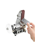 Compact Mini Electric Belt Sander, Versatile Desktop Grinding Machine For Wood And Metal Polishing in use with metal piece.