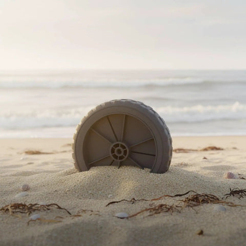 Beefy Tank Wheel With Bearing For Carts And Equipment Transport 5 Inch Universal Fit Rubber Wheel on a sandy beach.