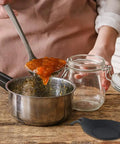 Using Three Piece Silicone Spoon Rest Set in kitchen with stainless pot and glass jar, Black utensil holder shown