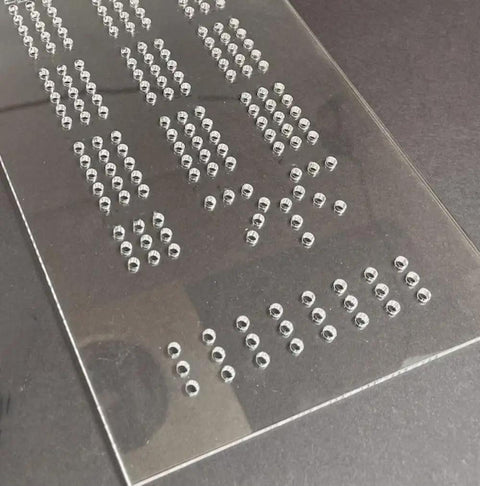 Built Tough Acrylic Cribbage Template And 1/4 Inch Thick Router Guide Kit For Building Slick Game Boards With Crisp Drill Marks And Tight Three Track Routing Project, showing precise hole spacing in clear acrylic.