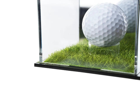 Golf ball displayed in a UV Protected Acrylic Display Case For Autographed Golf Balls And Memorabilia With Adjustable LED Lighting on grass