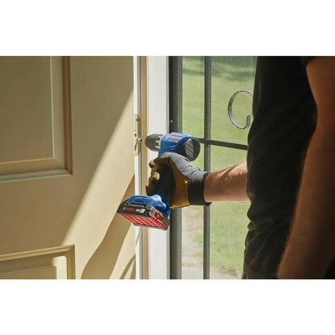 Person using 18V Compact Brushless Drill Driver Kit With One Half Inch Chuck And 2 Ah Battery, Pro Grade Power on door frame.