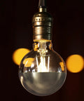 Dimmable Anti Glare G25 Globe LED Bulb Dope 7W 75W Eq E26 Silver Dipped Half Chrome Top, 3000K Warm White hanging in a socket