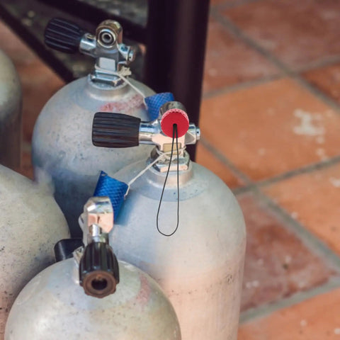 Red Scuba Tank Regulator Cap And Air Valve Protector Cover With Cord dust plug on diving tank in warm setting