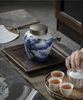 Solid Ceramic Tea Canister For Loose Leaf Storage, Airtight Kitchen Jar displayed on a tray with tea cups.