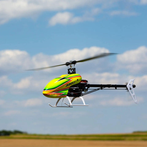 330 S RTF Basic Drone With Safe Technology in flight, showcasing bright colors and sleek design against a blue sky with clouds.