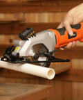 Yunirvana mini circular saw, side view, with laser guide and orange housing cutting PVC pipe.