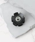 Two Pack Bicycle Front Fork Bowl Star Nuts For One And A Quarter Inch Diameter Forks With M6 Threads And Twenty Nine Point Four Millimeters Width, black finish on concrete surface