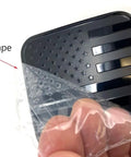 Black Metal Flag Trailer Hitch Cover For 2 Inch Receivers with protective tape being removed, patriotic flag design visible