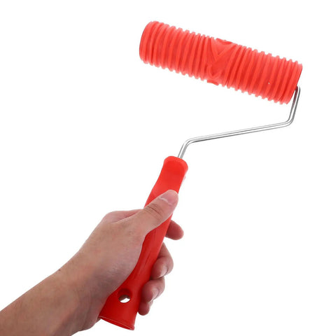 Top Tier Premium Grain Pattern Paint Roller With Slick Plastic Handle For Smoothing Over Bare Drywall And Crafting Embossed Textures That Look Absolutely Badass held in hand with red rubber cover.