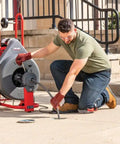 Heavy Workhorse 115 Volt Drain Cleaning Machine With Auto Feed Cable Control And 5 8 Inch Tool Kit For Lateral Lines in use outdoors.