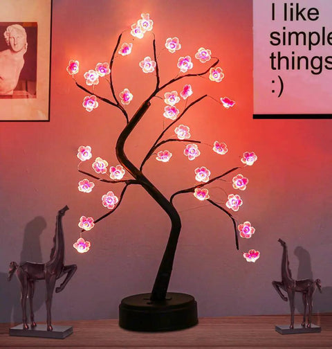 Cherry Blossom Tree Lamp For Living Room Decor And Cozy Night Light, DIY Artificial Tree Light For Home Weddings Christmas And More, USB Or Battery Powered Ambience showing pink LED blossoms on a black trunk on a tabletop.