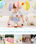 Baby with cupcake and dog under Colorful Hot Air Balloon Paper Garland Set 5 Pieces For Room Party Decor With Clouds And Stars.