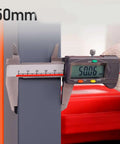 Measuring the thickness of the bolted down heavy duty steel workbench, showing 50.06 mm with calipers.
