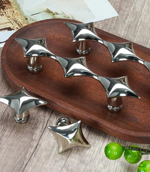 Spruce Up Your Day To Day Kitchen Cabinets Or Lazy Sunday Bathroom Vanities With These Clean Star Design Drawer Pulls In Crisp Silver Finishing. Modern star-shaped silver drawer pulls on a wooden tray.