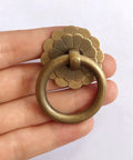Close-up of Six Pack Vintage Style Brass Ring Pulls Set 2.5 Cm Ring Diameter With 0.87 Inch Screws, solid brass in hand