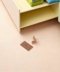 20 Piece Plastic And Iron Drawer Stopper Set for dressers and cabinets shown near a drawer with brown glide pads visible