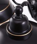Close-up of oil rubbed bronze finish on two light farmhouse wall sconce with gold highlights, vintage style detail.