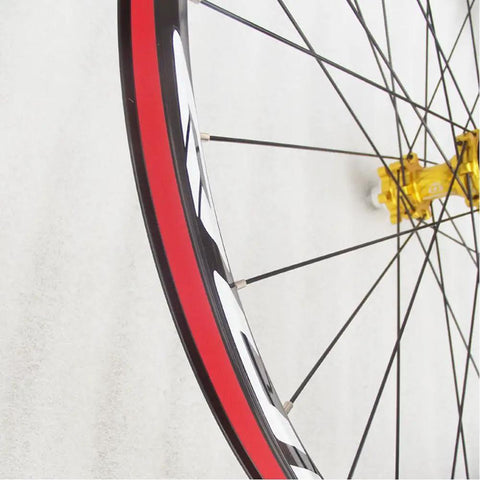 Close-up of bike rim with red rim tape, part of Eight Pack Bike Rim Tape And Three Tire Levers Kit For 26 Inch Or 700C Rims